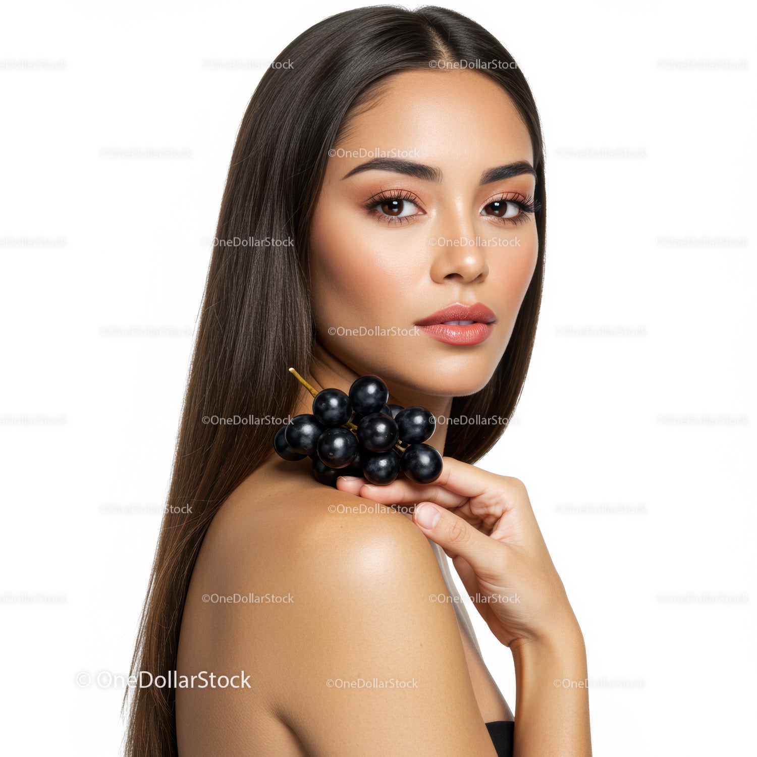 Elegant Woman with Long Dark Hair Holding Black Grape for Beauty and Wellness