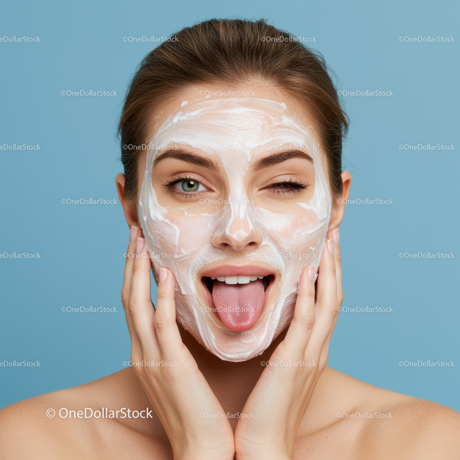 Young Woman Playfully Applying Facial Mask with Clear Skin and Bright Expression