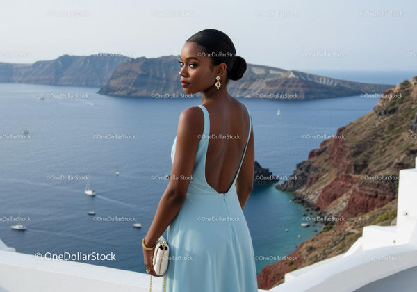 Woman in elegant dress overlooking Mediterranean coast