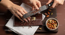 Gourmet Chocolate Bar with Nuts and Chocolate Grater on Wooden Board