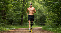 Male Runner with Prosthetic Leg Running Through Foggy Forest Trail