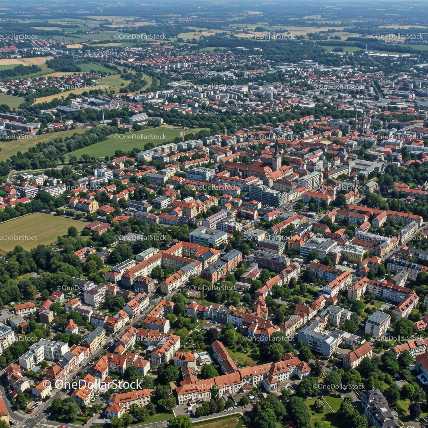 Widok z lotu ptaka na historyczne i nowoczesne miasto z czerwonymi dachami i zielonymi parkami