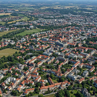 Aerial View of Historic and Modern City with Red Roofs and Green Parks