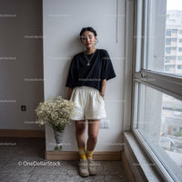Young Woman in Casual Streetwear Standing Near Window in Urban Setting
