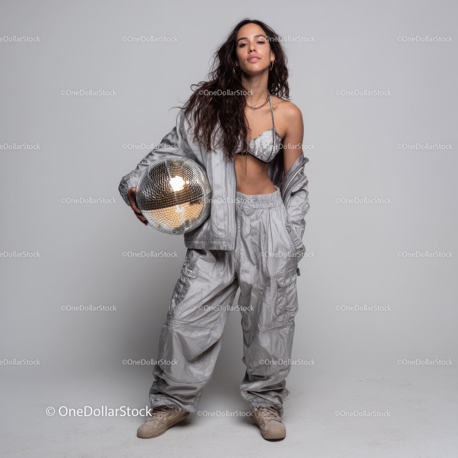 Stylish Woman in Metallic Outfit Holding Disco Ball for Modern Fashion