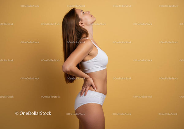 Elegant Woman in White Sportswear Posing Against Yellow Background