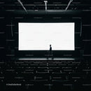 Man walking across empty dark movie theater stage