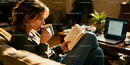Young woman enjoying coffee while reading at home