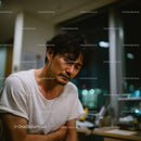 Contemplative Man in Casual Clothing with Night City Background
