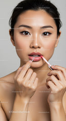 Young Woman Applying Lip Gloss with Flawless Skin and Elegant Look