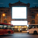 Historic brick building with illuminated blank billboards at night