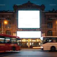 Historic brick building with illuminated blank billboards at night