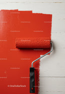 Red Paint Being Applied with Roller on White Wall for Home Renovation