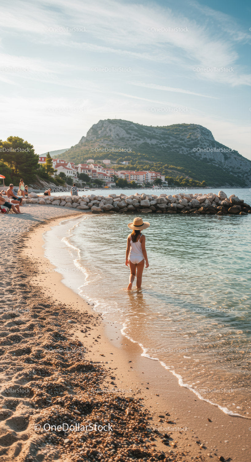 Spokojna plaża z młodą dziewczyną brodzącą w spokojnych wodach oceanu