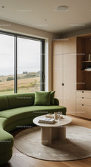 Cozy modern living room with green curved sofa and scenic view