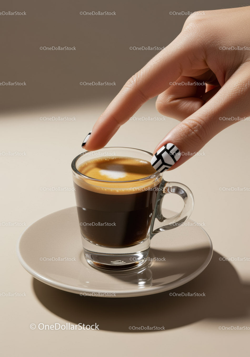 Ręka z wyrazistym zdobieniem paznokci dotykająca świeżej filiżanki espresso