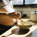 Pregnant woman preparing a healthy breakfast in kitchen