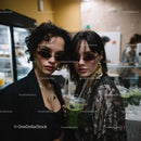 Fashionable Women with Sunglasses and Green Drink in Trendy Night Scene