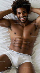Smiling handsome man relaxing on bed in white underwear