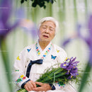 Elderly woman in traditional hanbok holding purple irises