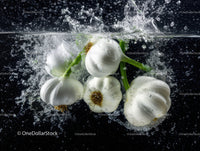 White Onion Bulbs Splashing into Water Underwater