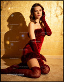 Elegant woman dressed in red velvet outfit posing indoors