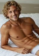 Smiling shirtless man relaxing on white bed at home