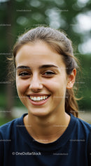 Young Woman Smiling Outdoors with Natural Light and Joyful Expression