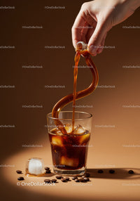 Pouring Iced Coffee with Coffee Beans on Brown Surface