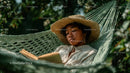 Woman Relaxing in Hammock Reading Book in Tropical Garden