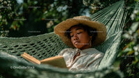Woman Relaxing in Hammock Reading Book in Tropical Garden