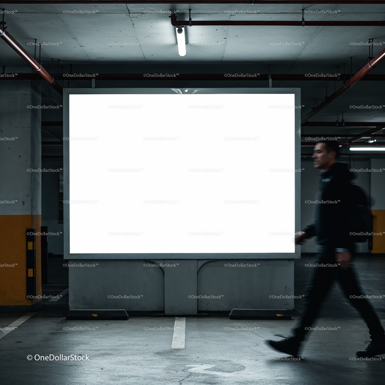 Man walking past illuminated blank billboard in parking garage