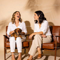 Two Women Enjoying Conversation With Dachshund Dog