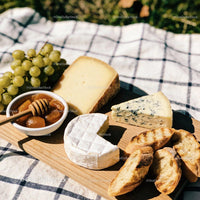 Assorted Cheese Platter with Grapes and Bread Outdoors