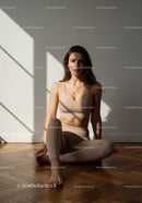 Young Woman Meditating in Sunlit Minimalist Room
