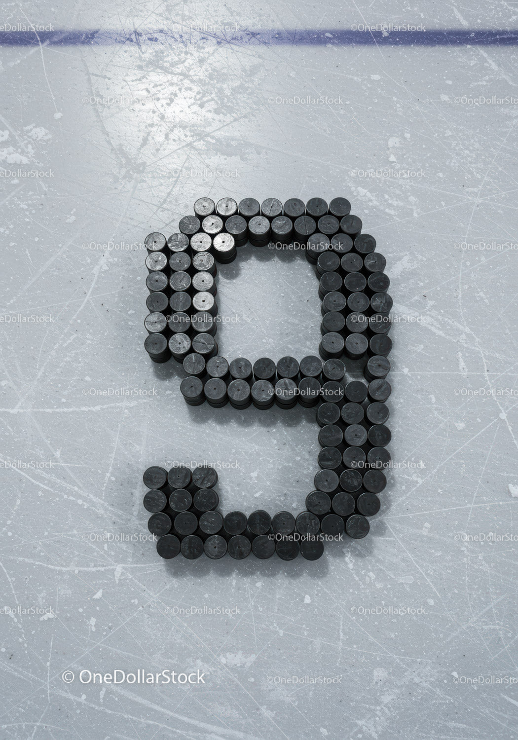Number Nine Formed From Hockey Pucks on Ice Rink