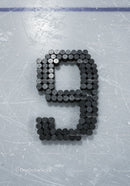 Number Nine Formed From Hockey Pucks on Ice Rink