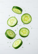 Fresh cucumber slices suspended in clear water droplets
