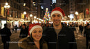 Smiling couple wearing Santa hats at city Christmas celebration