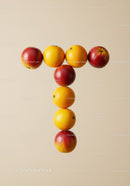 Oranges and nectarines arranged in a T shape on beige