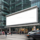 People walking in front of modern storefront with blank billboard