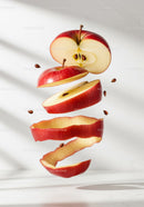 Floating sliced red apple with scattered seeds