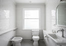 Modern White Bathroom with Tiled Walls and Natural Light