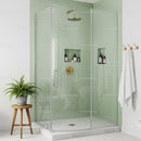 Modern glass shower with green tiles and brass fixtures