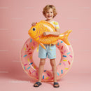 Smiling boy with inflatable fish and donut float ring