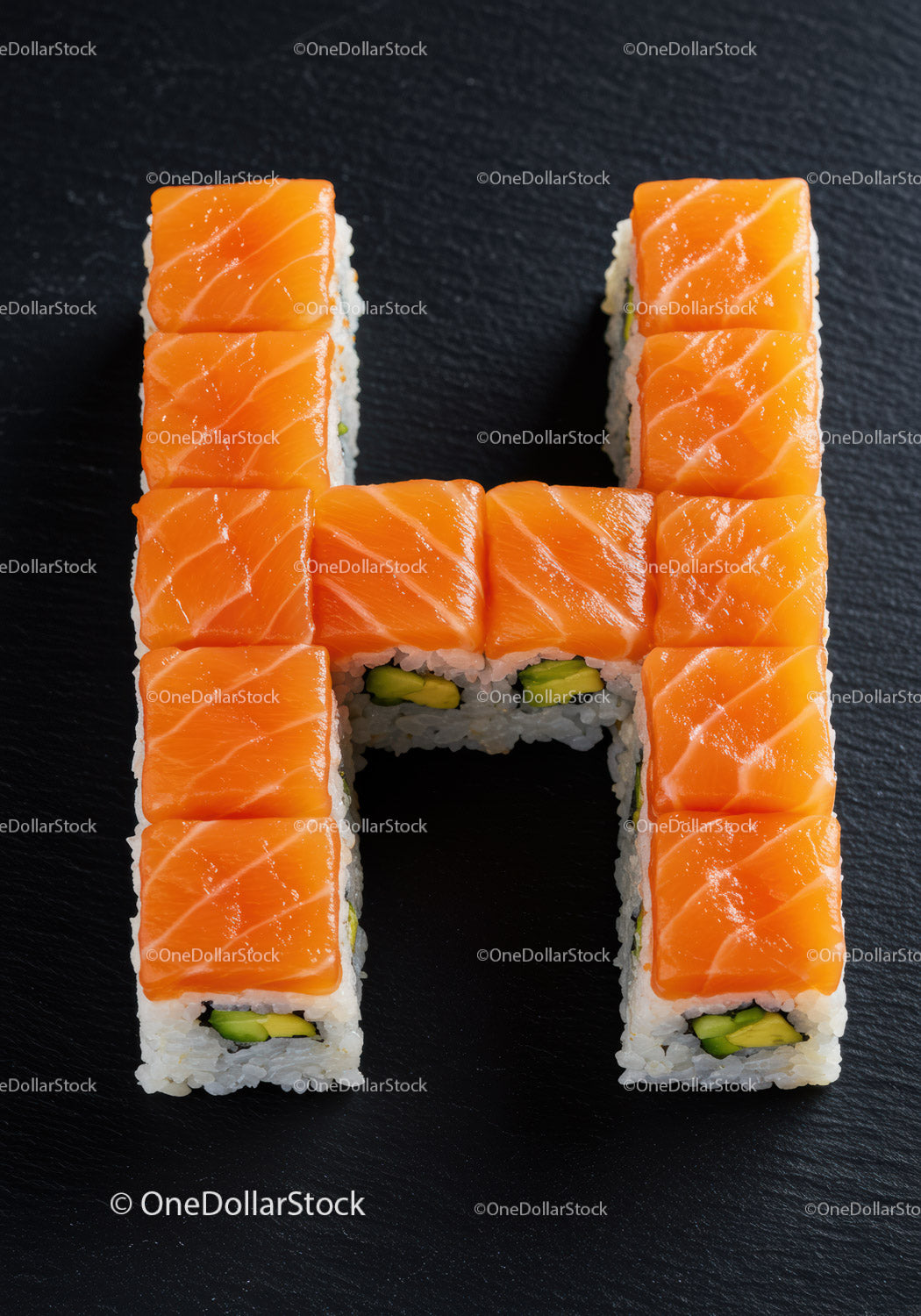 Rolki sushi z łososiem ułożone w literę H na czarnym talerzu