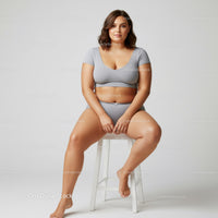 Plus Size Woman in Gray Lounge Wear Sitting Confidently on a Stool
