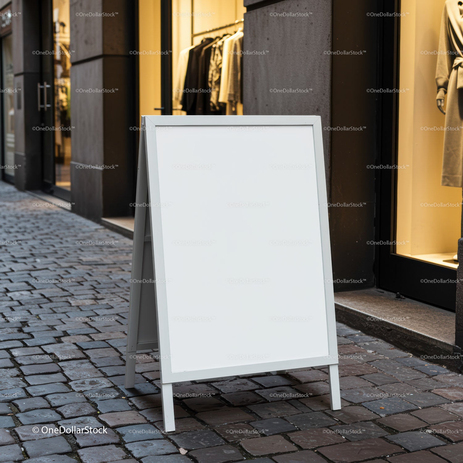 Blank white sandwich board on cobblestone street near store