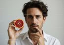 Professional Portrait of a Man Holding a Blood Orange Slice for Wellness and Lifestyle