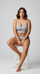 Relaxed Woman Sitting on Stool Wearing Gray Sportswear in Studio